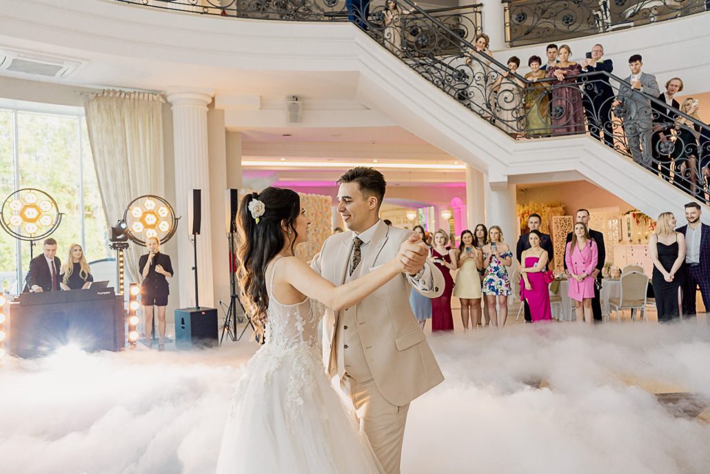 Julia i Krzysztof w czułym objęciu, romantyczny portret ślubny w świetle zachodzącego słońca.