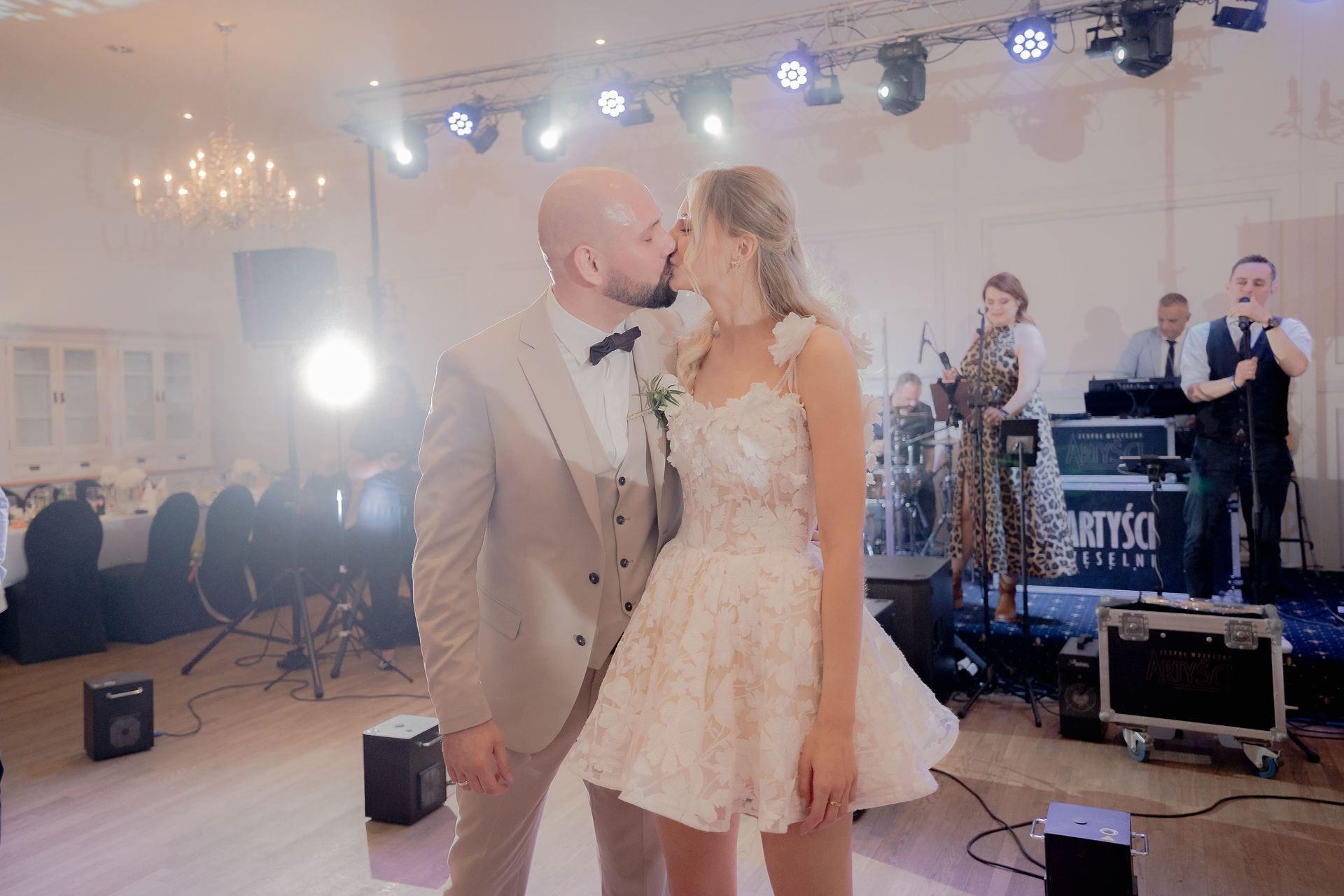 Kinga and Piotr’s first kiss as a married couple at the end of their wedding ceremony as guests applaud in the background.