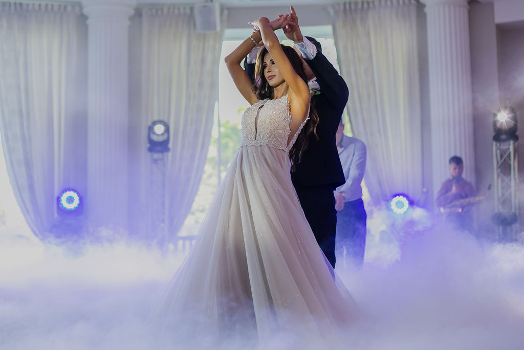 Sylwia & Paweł holding hands at their wedding celebration in warm light